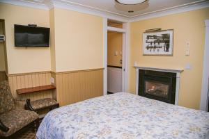 a bedroom with a bed and a fireplace at Salt Spring Inn in Ganges