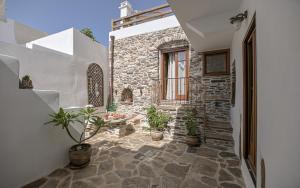 a courtyard of a house with potted plants at Memorias Sangri Naxos in Áno Sangríon
