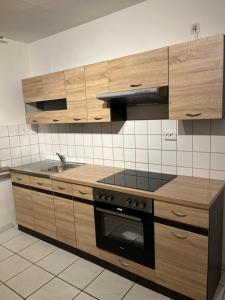 een keuken met houten kasten en een fornuis met oven bij Zimmer für Monteure, Handwerker oder Reisende in Essen