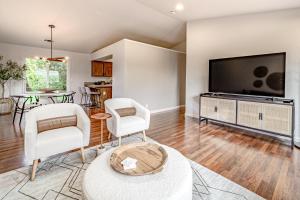 ein Wohnzimmer mit einem Flachbild-TV und Stühlen in der Unterkunft Hedge Rose House in McKinleyville