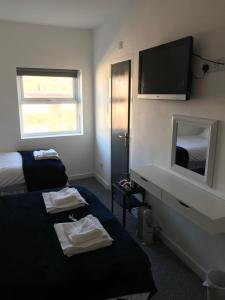 a hotel room with a bed and a flat screen tv at Alexandra Hotel in Blackpool