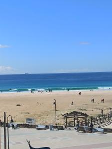 a beach with people on the sand and the ocean at Apartamento Lances playa tarifa in Tarifa