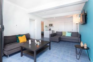 a living room with two couches and a table at Airlie Sun & Sand Accommodation #3 in Airlie Beach