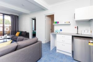 uma sala de estar com um sofá e uma cozinha em Airlie Sun & Sand Accommodation #3 em Airlie Beach