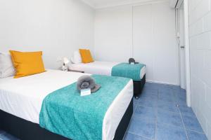um quarto com duas camas e uma toalha numa mesa em Airlie Sun & Sand Accommodation #3 em Airlie Beach