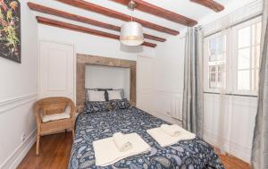 a bedroom with a bed with two towels on it at River apartment center downton in Lisbon