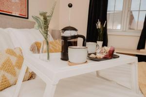 a white table with a coffee maker and cups on it at Coyle House, 3 bed,Corby, super kings or twins, driveway, free wi-fi, corporates welcome in Corby