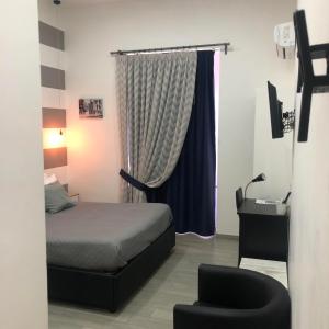 1 dormitorio con 1 cama, 1 silla y 1 ventana en Napoli DownTown, en Nápoles