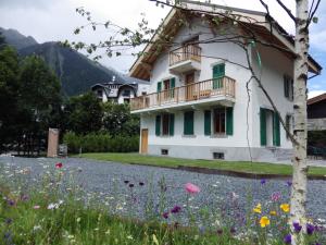 uma casa com varanda e um campo de flores em Chalet Oryx em Chamonix-Mont-Blanc