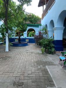 a courtyard of a blue building with chairs and trees at Copper Canyon Riverside Lodge in Batopilas