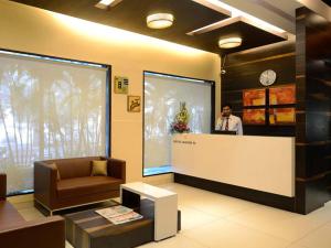a man standing at a counter in a lobby at Hotel Grande 51 in Navi Mumbai