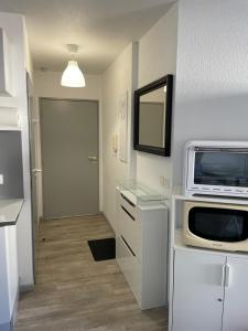 a room with a microwave and a door with a hallway at Appartement HOSSEGOR plage SUD Classé 3 étoiles in Soorts-Hossegor +61 photos