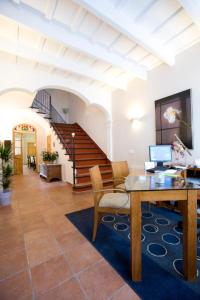 a living room with a table and a staircase at Hotel Es Mercadal in Es Mercadal