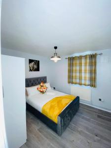 una camera da letto con un letto con una coperta gialla sopra di Bright, Spacious, modern Interior Decor 2 bedrooms Apartment with amazing views a Londra