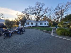 una casa blanca con mesas y sillas frente a ella en Sonoma Creek Retreat NEW LISTING, en Kenwood