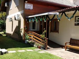 una casa con un porche con un banco delante en Pousada Genial, en Gramado