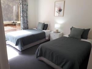 a bedroom with two beds and a window at Roshnier Apartment in Warrnambool