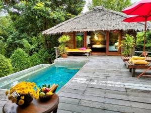 un complexe avec une piscine et un pavillon dans l'établissement Thap Pala Cottage, à Songkhla
