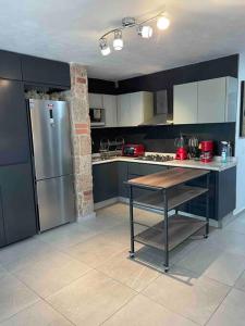 a kitchen with a refrigerator and a table in it at Alojamiento completo, con una excelente ubicación in Guadalajara