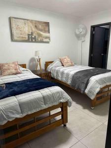 a bedroom with two beds and a fan at Alojamiento completo, con una excelente ubicación in Guadalajara