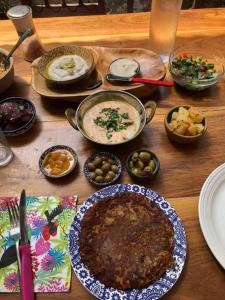 una mesa de madera cubierta con platos y tazones de comida en פינה קסומה בהר en Lotem