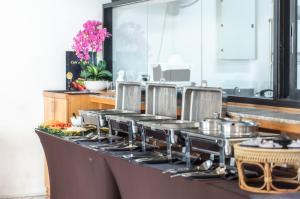 un mostrador de cocina con un montón de ollas y sartenes en The Proud Exclusive Hotel-SHA Plus en Nakhon Pathom