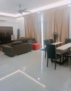 a living room with a couch and a table and chairs at MR 16 Homestay Putrajaya Dwiputra in Putrajaya