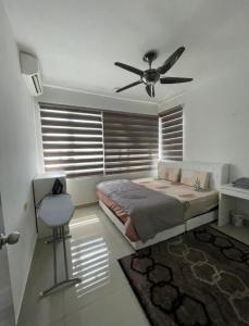 LA 16 HOMESTAY Putrajaya Dwiputra في بوتراجايا: غرفة نوم بسرير ومروحة سقف