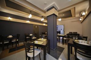 a dining room with tables and chairs in a restaurant at Continental Hotel in Kutaisi