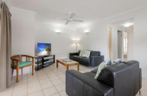 a living room with a couch and a chair at Central Plaza Port Douglas in Port Douglas
