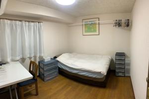 Un dormitorio con una cama, un escritorio y una mesa. en Tokyo Kakan, en Tokio