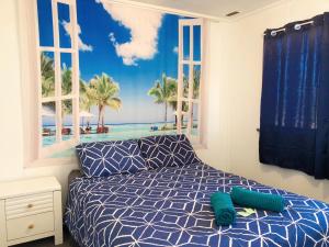 a bedroom with a bed with a mural of the beach at Shark Bay Cottages in Denham
