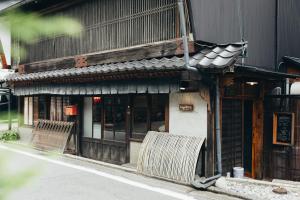 a building with two benches in front of it at Yamairo guesthouse in Iida