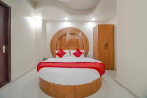 Hotel Classic Paradise Inn في نيودلهي: غرفة نوم بسرير كبير مع اللوح الخشبي