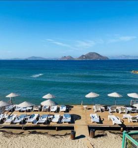 a group of lounge chairs and umbrellas on a beach at Rahat Ev in Bodrum City