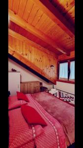 1 dormitorio con 1 cama grande con almohadas rojas en HOME PREDIL en Tarvisio