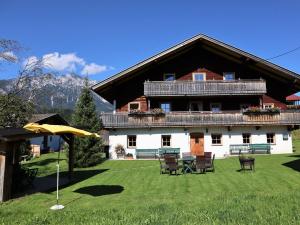 a large house with a table and chairs in the yard at Farmhouse in Söll near Wilder Kaiser Ski Area in Söll