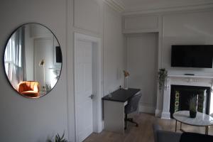 a living room with a mirror and a piano at Crawford House- ScholarLee Living Apartments in Cork