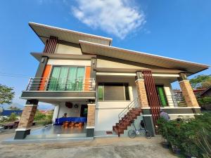 une maison avec une terrasse couverte et un balcon dans l'établissement สวัสดีปัวโฮมสเตย์ Sawaddee Pua Homestay, à Pua