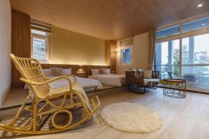 ein Hotelzimmer mit einem Bett und einem Stuhl in einem Zimmer in der Unterkunft 茉白電梯民宿Bed and Breakfast Elevator 花蓮夜市電梯包棟 in Hualien