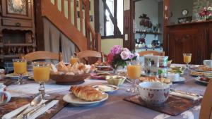 a table with a breakfast of croissants and orange juice at Les sources in Poilley