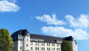 a large white building with a black roof at Best Boarding House in Hanau am Main
