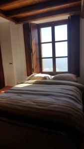 sypialnia z dużym łóżkiem i oknem w obiekcie Athina Guesthouse w mieście Monemwasia