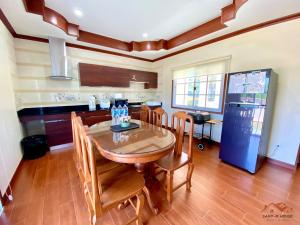 a kitchen with a table and chairs and a refrigerator at Sand-D House Pool villa B30 at Rock Garden Beach Resort Rayong in Mae Pim