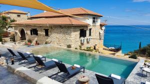 a house with a swimming pool next to the ocean at Xigia Escape villas in Khartáta