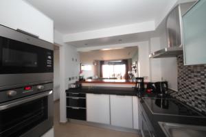 a kitchen with black counter tops and a stove top oven at Mar da Luz, Algarve in Luz