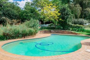 a swimming pool with a hose in the water at Oakdene Cottage in Roodepoort