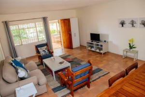 un soggiorno con un divano e un tavolo di Oakdene Cottage a Roodepoort