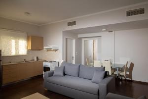a living room with a couch and a table and a kitchen at Alkistis Hotel in Diakopto