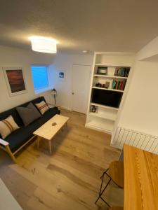 un salon avec un canapé et une table dans l'établissement Cheerful one bedroom cottage in Mousehole., à Mousehole